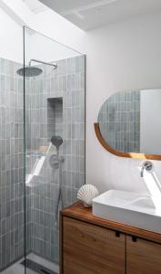 a bathroom with a shower and a sink at OKTO Beach House in Praia do Almoxarife +27 photos