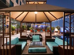 a patio with couches and a large umbrella at Novotel Pune Viman Nagar Road in Pune