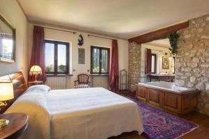a bedroom with a bed and a bath tub at Villa Terrarossa with Pool in the Vineyard in Mezzane di Sotto +91 photos