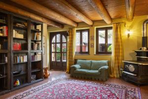 a living room with a couch and a chair and a fireplace at Villa Terrarossa with Pool in the Vineyard in Mezzane di Sotto