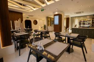 a restaurant with tables and chairs and a bar at Nearest Airport Hotel in Arnavutköy