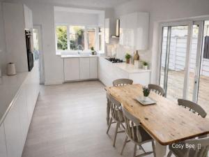 a kitchen and dining room with a wooden table and chairs at Cosy Bee in Bournemouth