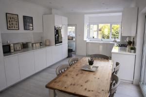 a kitchen and dining room with a wooden table and chairs at Cosy Bee in Bournemouth