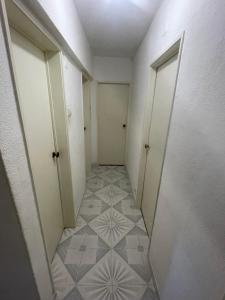 an empty hallway with two doors and a tiled floor at my house in Lisbon +2 photos