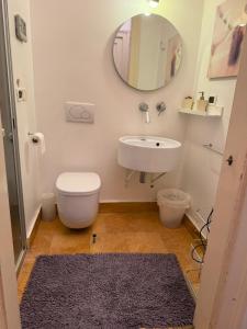 a bathroom with a sink and a toilet and a mirror at Centro - doppia in casa d'artista in Turin