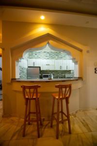 a kitchen with two stools in front of a counter at New Villa Carimo in Quseir