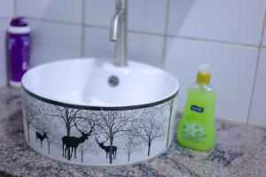 a bathroom counter with a sink and a bottle of soap at The Comfort Den in Kampala