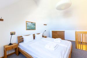 a bedroom with a bed with white sheets and towels at Kiek Över in Ahrenshoop