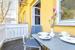 a blue table with a vase of flowers on a balcony at Kiek Över in Ahrenshoop +20 photos