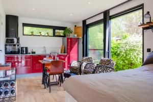 ein Schlafzimmer mit einem Bett und eine Küche mit roten Schränken. in der Unterkunft Recup in Beernem