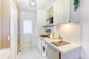 a white kitchen with a sink and a dishwasher at Parking free - cosy & elegant in LʼHay-les-Roses