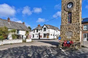 a building with a clock tower on the side of a street at Finest Retreats - The Rectory Nook Annexe in Saint Teath