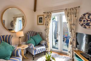 a living room with two chairs and a mirror at Finest Retreats - The Rectory Nook Annexe in Saint Teath