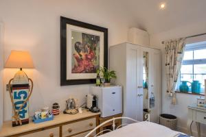 a bedroom with a bed and a picture on the wall at Finest Retreats - The Rectory Nook Annexe in Saint Teath
