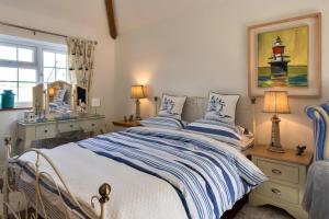 a bedroom with a bed with two pillows and a mirror at Finest Retreats - The Rectory Nook Annexe in Saint Teath