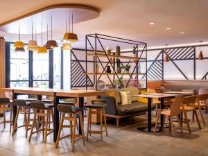 a restaurant with tables and chairs in a room at Ibis Styles Colmar Centre in Colmar