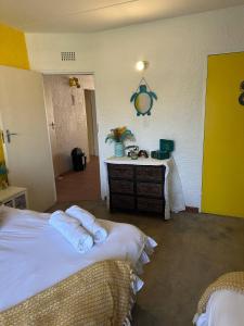 a room with two beds and a table with towels at Retro at The Vaal - entire Flat in Denysville
