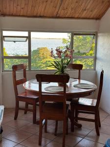 a table and chairs with a vase of flowers on it at Retro at The Vaal - entire Flat in Denysville +16 photos
