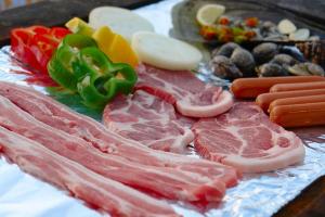 a group of meats and vegetables on a table at Buan Solseom House Pension in Buan