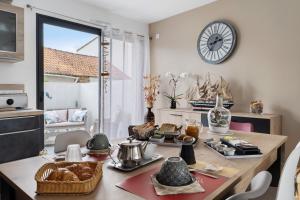a kitchen with a table with a clock on the wall at Chambre D'hôtes - Chambre Marine in La Plaine-sur-Mer