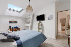 a bedroom with a bed and a tv on the wall at Chambre D'hôtes - Chambre Marine in La Plaine-sur-Mer