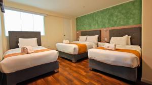 a hotel room with three beds and a green wall at Hotel Terrazas del sol in Arequipa +33 photos