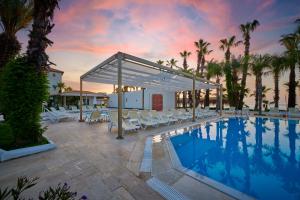 a swimming pool with white lounge chairs at Fun Sun Smart Akman Beach in Kemer