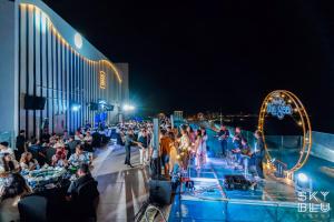 a crowd of people standing around at a party at night at The Zenix Hotel Seaview in Nha Trang +130 photos