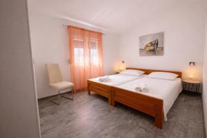 a bedroom with a bed and a chair and a window at Holiday Home Pakoštane in Pakoštane +18 photos