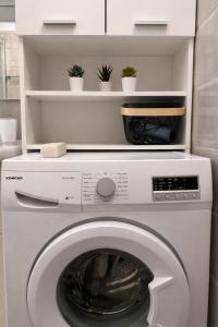 a washing machine in a kitchen with plants on shelves at Holiday Home Pakoštane in Pakoštane