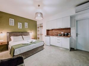 a bedroom with a large bed and a kitchen at Meraki Nikiti in Nikiti