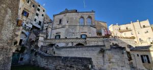 an old stone building with a tower on top of it at Vistasassi rooms in Matera
