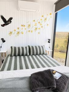 a bedroom with a bed with a bird on the wall at Gem near the Dam by Tiny Away in Romsey