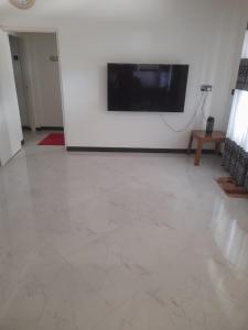 a living room with a flat screen tv on a wall at Avona Villa in Bopitiya