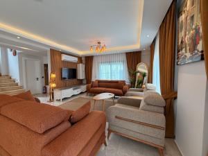 a living room with two couches and a television at As Villas Villa Asil in Fethiye