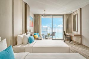 a hotel room with two beds and a balcony at The Atier Gem Suites in Nha Trang +111 photos