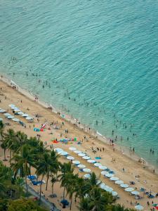 a group of people on a beach with umbrellas at The Atier Gem Suites in Nha Trang