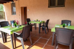 a restaurant with green tables and chairs at Bed And Breakfast Nonna Pia in Fertilia