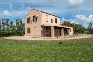 a house sitting on top of a grass field at Bed And Breakfast Nonna Pia in Fertilia