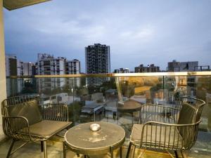 a balcony with chairs and tables and a view of a city at Hotel Tattva Suites NIBM, next to Corinthians Club in Pune
