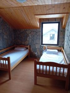 two beds in a room with a window at Kompleks Gurman in Pʼklište