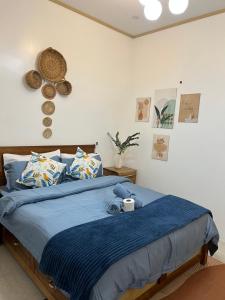 a bedroom with a bed with a blue comforter at A-rena Homestay in General Luna