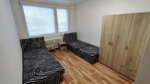 a bedroom with two beds and a large window at Apartmán pro 6 osob, Most M2 in Most