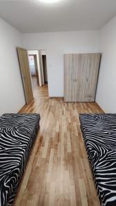 two beds in an empty room with wooden floors at Apartmán pro 6 osob, Most M2 in Most