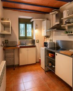 a kitchen with white cabinets and a tile floor at Apartamentos Saltarel·lo in Besalú