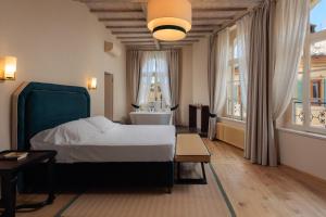 a bedroom with a bed and a large window at Palazzo Saloni in Montalcino