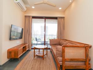 a living room with a couch and a tv and a table at Hotel Tattva Suites NIBM, next to Corinthians Club in Pune