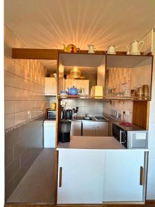 a small kitchen with white cabinets and a light at SPACIEUX STUDIO 3 étoiles SUR BOLQUERE PYRENEES 2000 in Font-Romeu +1 photo