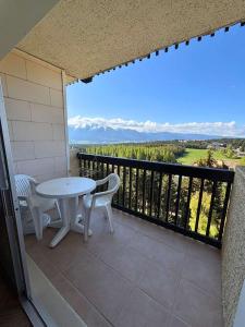a patio with a table and chairs on a balcony at SPACIEUX STUDIO 3 étoiles SUR BOLQUERE PYRENEES 2000 in Font-Romeu
