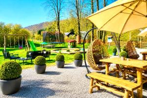 a picnic table and chairs with an umbrella and a playground at pension U Jiřího in Ludvíkov +11 photos
